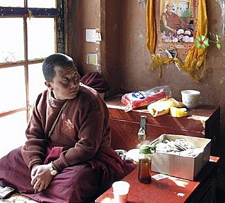 A monk sits beside an altar at Drepung Temple in Lhasa