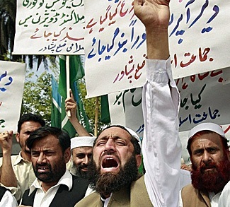 Dozens of men associated with the right-wing Islamic party Jamaat-e-Islami chant slogans in the streets of Peshawar