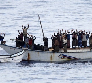 NATO handout photo showing hostages and pirates standing with hands up before intervention of Dutch NATO soldiers off Somalia's coast