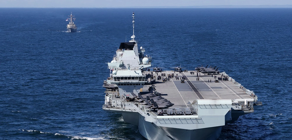 cc Commander, U.S. Naval Forces Europe-Africa/U.S. 6th Fleet CNE CNA C6F , modified, HMS Prince of Wales and HMS Queen Elizabeth pictured at sea for the first time with USS The Sullivans. Wednesday 19 May 2021 saw a historic moment in Britain’s carrier renaissance as HMS Queen Elizabeth and HMS Prince of Wales met at sea for the first time. With two 65,000 tonne carriers in operational service, Britain has a continuous carrier strike capability, with one vessel always ready to respond to global events at short notice. / https://www.flickr.com/photos/cne-cna-c6f/51199726246