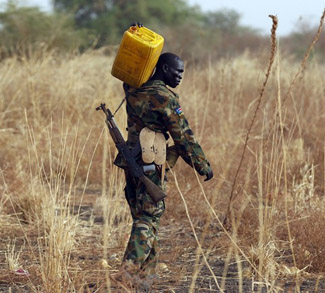 A South Sudan's army, or the  SPLA, soldier carries water to his position on the frontline in Panakuach