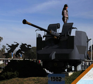 A girl stands on a cannon at an Argentine Falklands
