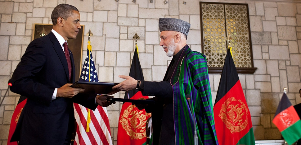 United States President Barack Obama and Afghan President Hamid Karzai exchange documents after signing the Enduring Strategic Partnership Agreement Between the United States of America and the Islamic Republic of Afghanistan at the Presidential Palace in Kabul, Afghanistan on 2 May 2012. / https://en.m.wikipedia.org/wiki/File:Barack_Obama_and_Hamid_Karzai_signing_strategic_partnership_agreement_May_1,_2012.jpg