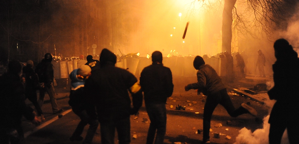 cc Mstyslav Chernov/Unframe, modified, https://commons.wikimedia.org/wiki/File:Protesters_throwing_pieces_of_paving_during_and_metal_tubes_at_riot_police_during_clashes_at_Bankova_str,_Kiev,_Ukraine._December_1,_2013.jpg