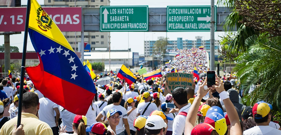                 cc r María Alejandra Mora (SoyMAM), modified, https://commons.wikimedia.org/wiki/File:Marcha_hacia_el_Palacio_de_Justicia_de_Maracaibo_-_Venezuela_06.jpg / La gente de la oposición marchó pacíficamente hasta las inmediaciones del Palacio de Justicia de la ciudad de Maracaibo.
              