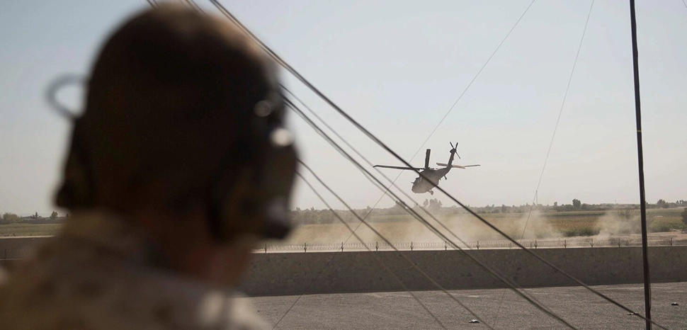                 A U.S. Marine advisor and joint-terminal attack controller with Task Force Southwest listens in as a UH-60 Blackhawk departs after a key leader engagement at Bost Airfield, Afghanistan, Oct. 21, 2017. Task Force and Helmand-based Afghan National Defense and Security Force leadership collaborated to discuss courses of action for the second phase of Operation Maiwand Seven. Multiple elements of ANDSF, including the Afghan National Army 215th Corps, 505th Zone National Police and National Directorate of Security among others are working in conjunction to clear the Nad’Ali district of Taliban insurgents. (U.S. Marine Corps photo by Sgt. Justin T. Updegraff) / https://www.centcom.mil/MEDIA/NEWS-ARTICLES/News-Article-View/Article/1356278/andsf-working-to-destroy-taliban-in-nadali-bringing-security-to-local-populace/
              