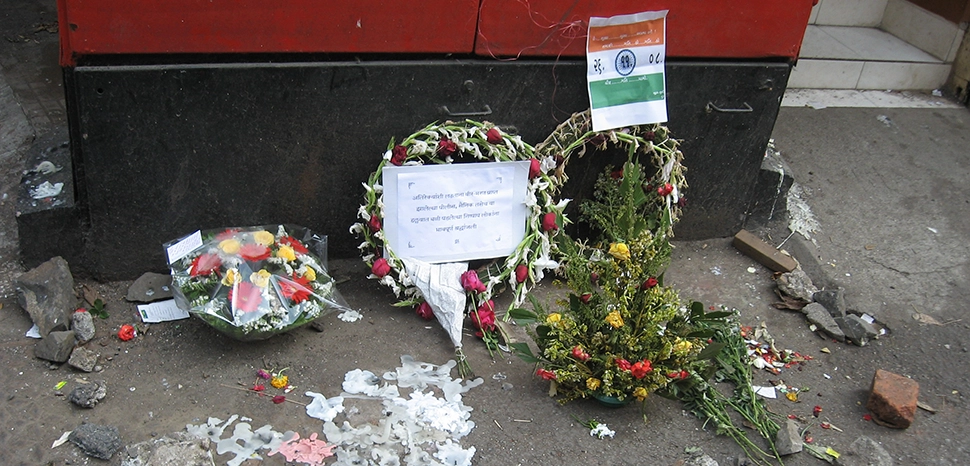 cc Nicholas (Nichalp), modified, The location of the spot where police officers Hemant Karkare, Ashok Kamte, Vijay Salaskar were gunned down by terrorists during the November 2008 Mumbai attacks / https://commons.wikimedia.org/wiki/File:2008_Mumbai_terror_attacks_flowers_at_spot_of_Karkare%27s_death.jpg