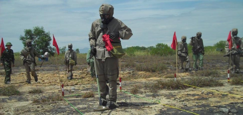 VietnamUXO, CC USAID Vietnam, modified, https://commons.wikimedia.org/wiki/File:Vietnam_starts_UXO_clearance_in_Danang_ahead_of_USAID-supported_dioxin_remediation_partnership_with_Vietnam_(5848584594).jpg