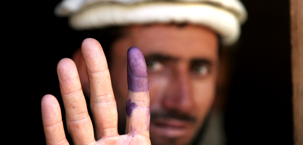 An Afghan elder shows his inked finger to show he voted during the heavily anticipated Afghanistan elections in Barge Matal, Afghanistan, Aug. 20, 2009. Afghanistan village elders are considered to be the role models and leaders among the Afghan civilians. U.S. Army soldiers helped provide security during the elections. U.S. Army photo by Staff Sgt. Christopher Allison, modified, https://commons.wikimedia.org/wiki/File:Inked_finger.jpg