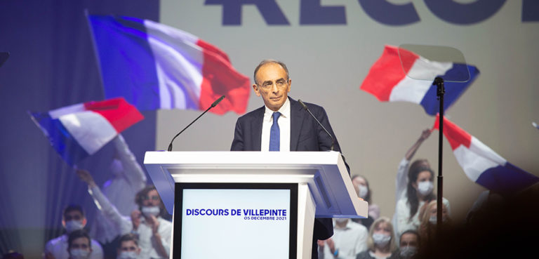 Eric Zemmour, modified, author: IllianDerex, https://commons.wikimedia.org/w/index.php?title=Special:Search&redirs=0&search=eric%20Zemmour&fulltext=Search&ns0=1&ns6=1&ns14=1&title=Special:Search&advanced=1&fulltext=Advanced%20search#/media/File:%C3%89ric_Zemmour_meeting_Villepinte_12-2021.jpg