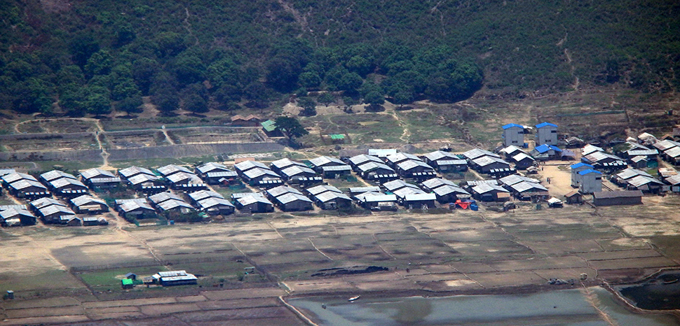 A Rohingya refugee camp in Bangladesh from the air; cc Flickr DYKT Mohigan, modified, https://flickr.com/photos/147860906@N07/30754564260/in/photolist-NRFbtW-ZwLFW4-K34bUx-Pf4JKV-Zhhkko-23khKpR-DSpE5T-21Y7rng-22rGNzf-DSpJxR-23khtuK-21jM37A-23wnEna-23wo5Te-21nwsZn-Gr8syr-21nwsWB-21jM2kq-21nwt9F-Gr8mEc-21jLZXq-21nwquc-21nvKAF-21nwqe2-ejB8En-21nwktv-ZhghuL-DKjqZ7-21hGDCm-21nuNor-21nvMcr-21nuQxg-21hGFJq-21nuRsx-JHQmrT-22rKBJG-21nwtwe-JrEbjz-a6T94J-Zhfpmd-PT3uFZ-ejGSvW-23ErzNe-Gr7oSa-21jKnjs-21nuPzV-21nuNNK-Zhfq6u-21jKmJ9-2dD9vWX