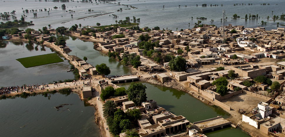 An aerial view of a town surrounded by flood water as U.S. Marine pilots from the 26th Marine Expeditionary Unit begin their landing approach to deliver food supplies in support of the Pakistan flood relief effort in Pano Aqil, Pakistan, Sept. 14. 55th Combat Camera Photo by Staff Sgt. Wayne Gray Date: 09.14.2010 Location: PANO AQIL AIR FIELD , PK