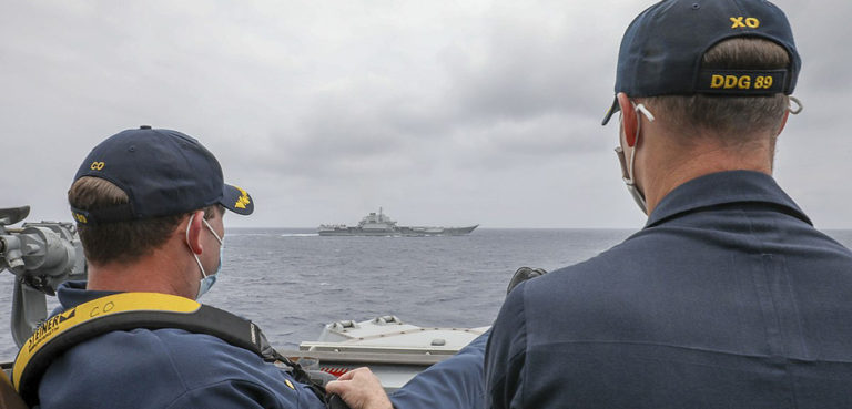 PHILIPPINE SEA (April 4, 2021) Cmdr. Robert J. Briggs and Cmdr. Richard D. Slye monitor surface contacts from the pilothouse of the Arleigh Burke-class guided-missile destroyer USS Mustin. Mustin is assigned to Task Force 71/Destroyer Squadron (DESRON) 15, the Navy’s largest DESRON and the U.S. 7th Fleet’s principal surface force. (U.S. Navy photo by Mass Communication Specialist 3rd Class Arthur Rosen)