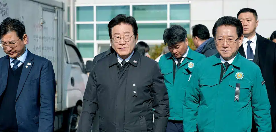                 cc Jeonnam Provincial Government , modified, https://commons.wikimedia.org/w/index.php?search=Lee%20Jae-myung&ns0=1&ns6=1&ns12=1&ns14=1&ns100=1&ns106=1#/media/File:Lee_Jae-myung_&_Kim_Yung-rok,_Jeju_Air_Flight_2216,_2_January_2025_01.jpg
              